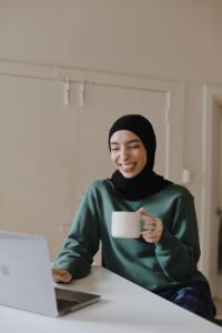 Woman in hijab using computer for therapy at home